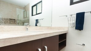 A modern bathroom with a large mirror, a sink, and a towel rack. - Amazing Tulum swim explore cycle by BRM (Tulum)