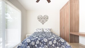 A bedroom with a bed, a wardrobe, and a heart-shaped wall decoration. - Amazing Tulum swim explore cycle by BRM (Tulum)