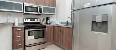 A modern kitchen with stainless steel appliances, wooden cabinets, and a built-in water dispenser.