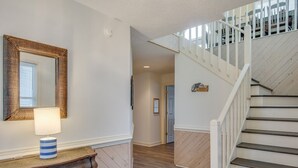 A staircase with white railings leading to an upper floor. - Dolphin Waves: Oceanside, Private Pool & Spa, Close to Beach, Quiet Neighborhood (Nags Head)