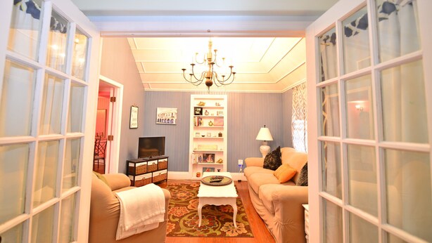 A living room with a sofa, a coffee table, a TV, and a bookshelf. - Historic Apartment in the Center of Christiansted (Christiansted)