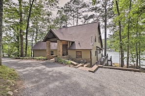Escape to a serene forested retreat with a tranquil lake view from the wooden dock.