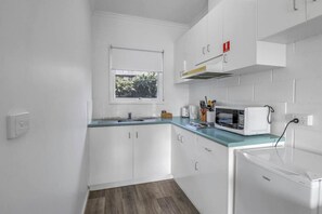 Kylskåp, mikrovågsugn, spishäll och grytor/köksredskap