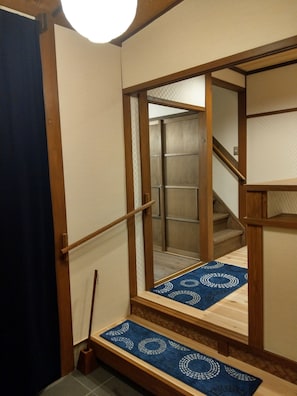 A wooden staircase with a blue patterned carpet leading to a room.