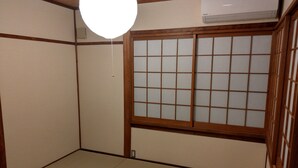 A traditional Japanese room with tatami flooring, a shoji screen door, and a ceiling fan. - Komatsucho 11-41 (Kyoto)