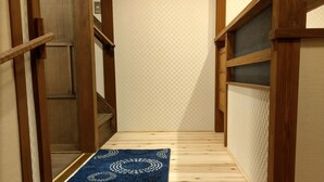 A narrow wooden staircase with a blue patterned rug at the bottom. - Komatsucho 11-41 (Kyoto)
