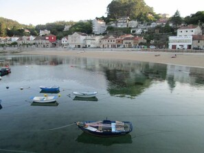 A calm waterfront with several small boats anchored near the shore.