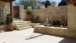 Step into a serene oasis with a stone wall and lush greenery, perfect for relaxation.