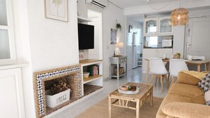 Una sala de estar moderna con chimenea, televisor y comedor.
