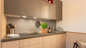 Una cocina moderna con armarios de acero inoxidable, una encimera negra y una planta en maceta.
