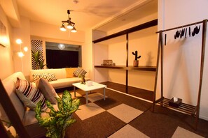 A modern living room with a sofa, coffee table, and potted plants.