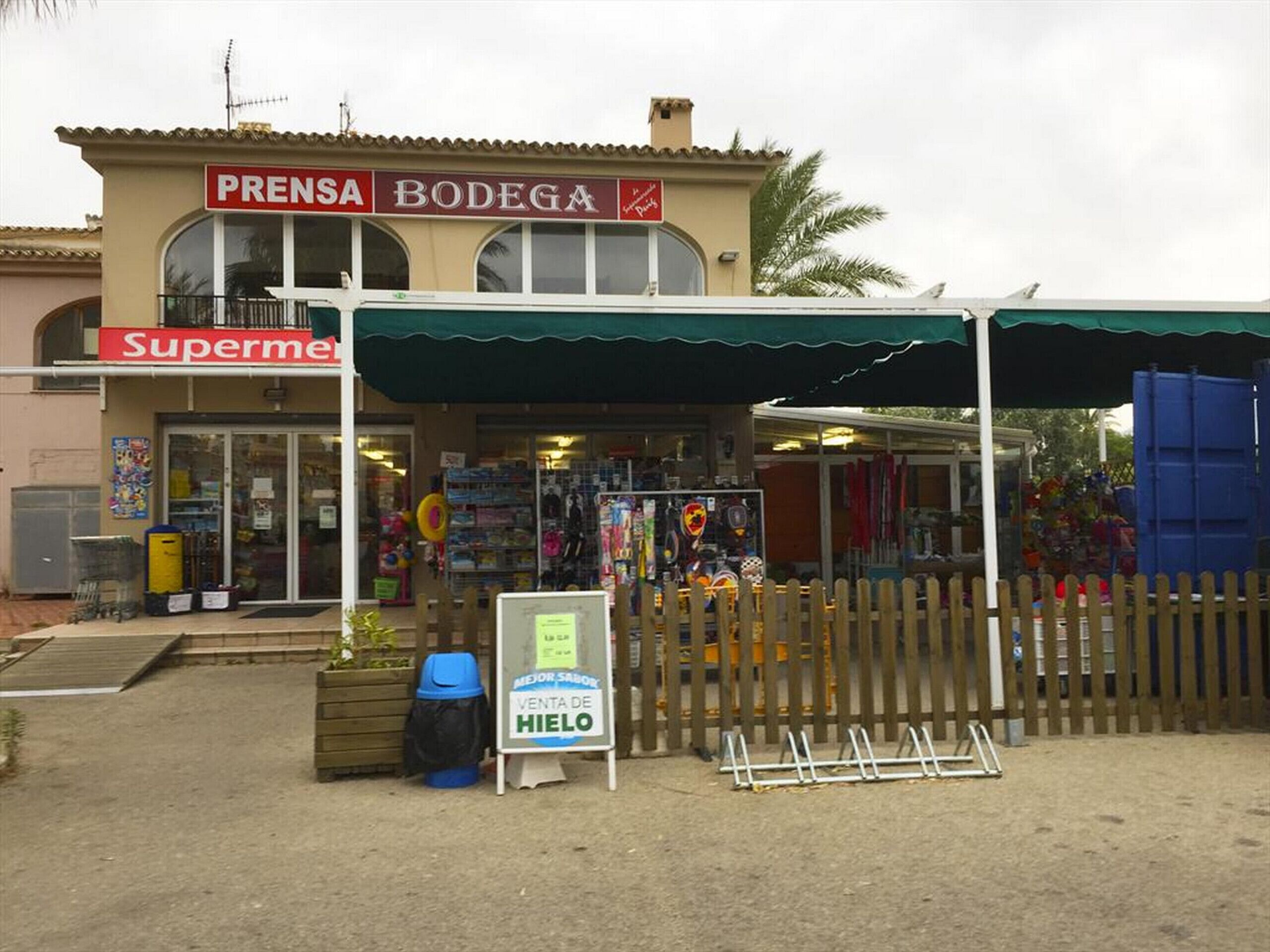 A store with a 'Supermercado' sign, a 'Bodega' sign, and a 'Venta de Hielo' sign.