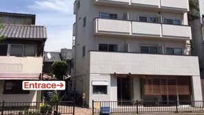 A multi-story residential building with a tiled facade, a visible entrance, and a balcony on the upper floors. - Comfort Inn Kyoto (Kyoto)