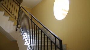 A staircase with black railings and a yellow wall.