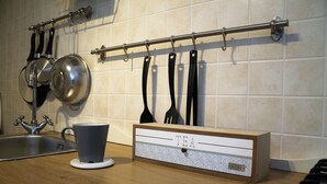A kitchen counter with a tea cup, a kettle, and a tea storage box.