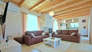 Ett modernt vardagsrum med två soffor, ett soffbord och en tv.