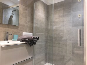 Regadera, secadora de cabello, toallas, papel de baño