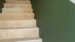 Una escalera con peldaños color beige que sube a un rellano.