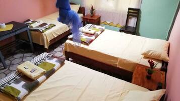 Une chambre d’hôtel avec deux lits, une petite table et une chaise.