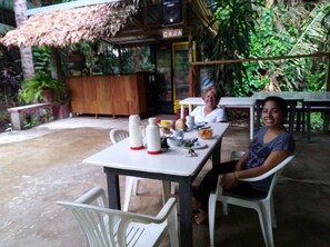 An outdoor dining area with a table set for two, surrounded by greenery. - Villa Hermosa de Tambopata (Tambopata)