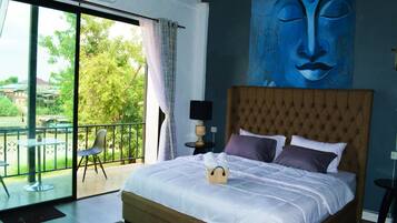 Un dormitorio con una cama grande, vistas al exterior y un cuadro en la pared.