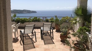 A balcony with two chairs and potted plants, overlooking a coastal view. - Fantastic detached house with GR. South Terraces + stunning views (Almuñécar)