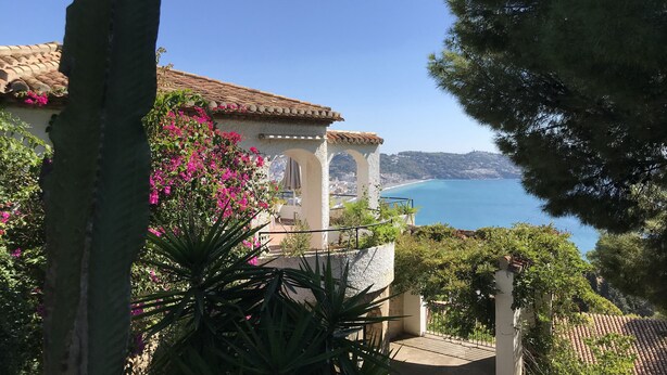A coastal villa with a terrace overlooking the sea, a pergola with pink flowers, and lush greenery. - Fantastic detached house with GR. South Terraces + stunning views (Almuñécar)