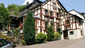 A traditional half-timbered building with a balcony, a stone staircase, and a cobblestone street. - Cozy half-timbered house for large groups / families up to 17 persons (Bacharach)