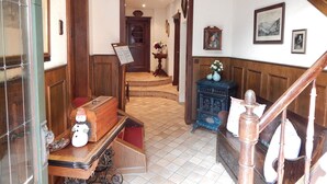A hallway with a wooden staircase, a small table with a snowman decoration, and a blue cabinet. - Cozy half-timbered house for large groups / families up to 17 persons (Bacharach)