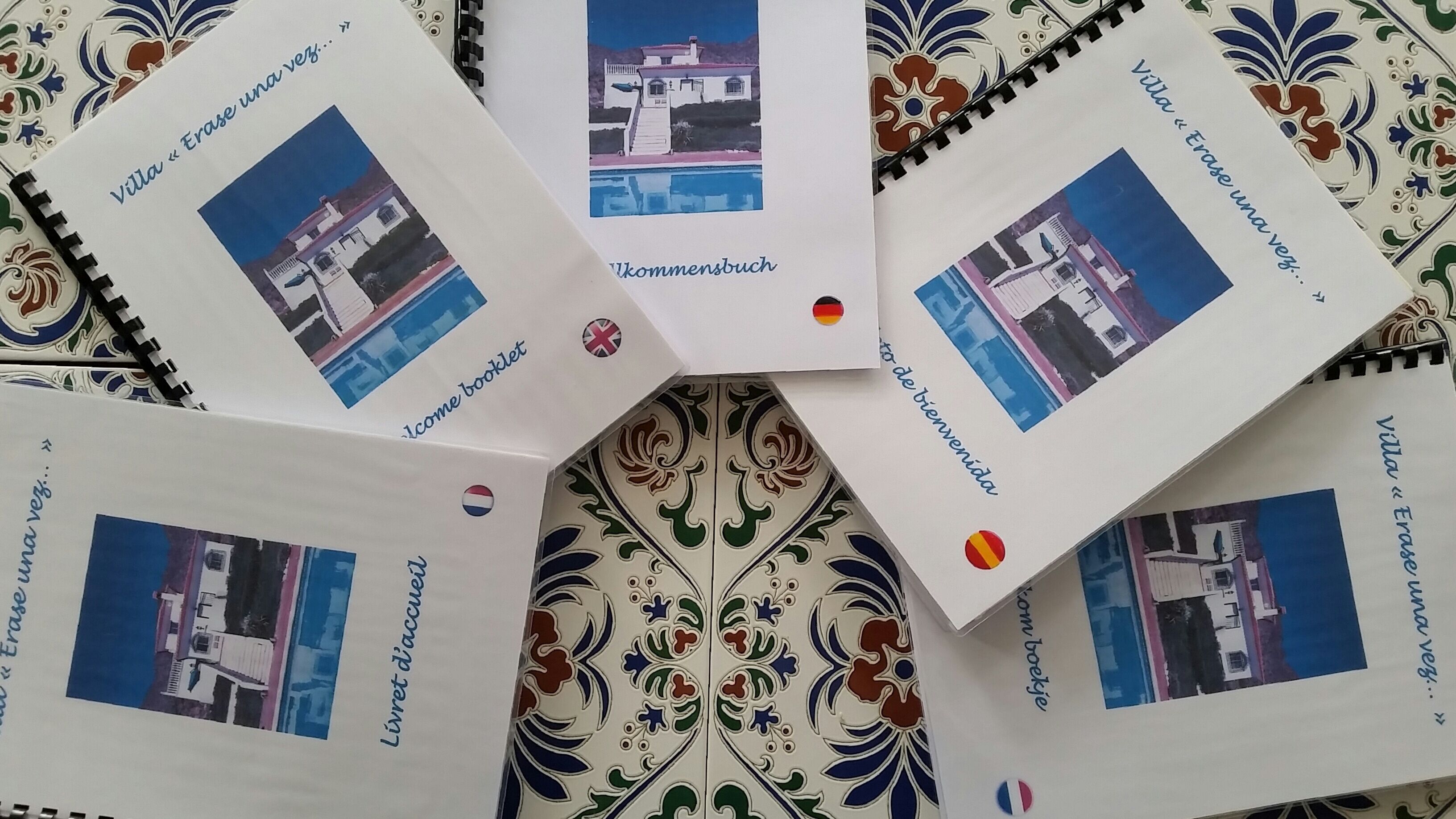 Un folleto con varias páginas, cada una con una fotografía de una villa y texto en varios idiomas.