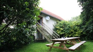 A house with a satellite dish, a wooden staircase, and a picnic table in a grassy yard. - Family-friendly with pets allowed and WiFi (Cérences)