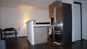 Una cucina moderna con forno integrato, microonde e frigorifero in acciaio inossidabile.