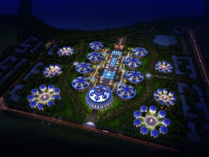 An aerial view of a large, circularly arranged complex with multiple domed structures, interconnected pathways, and a central square.