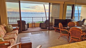 A balcony with wicker furniture, a TV, and a view of the sea. - DIRECT Oceanfront! Amazing Panoramic View Sugar Beach 236! Refresh, Relax, Enjoy (Kihei)