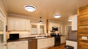 Una cocina moderna con armarios blancos, electrodomésticos de acero inoxidable y suelo de madera.