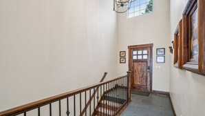 Una escalera con barandillas de madera y una puerta al final.