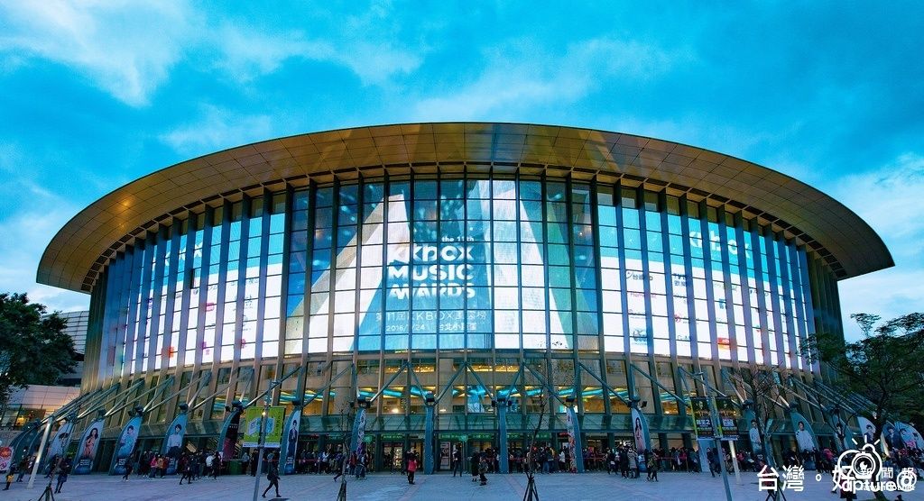 A modern, circular building with large glass windows and a prominent sign for the Knox Music Awards.