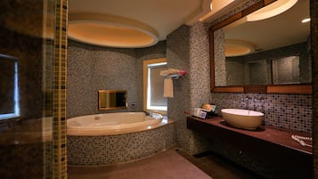 Un baño moderno con una bañera grande, un lavabo y un espejo.