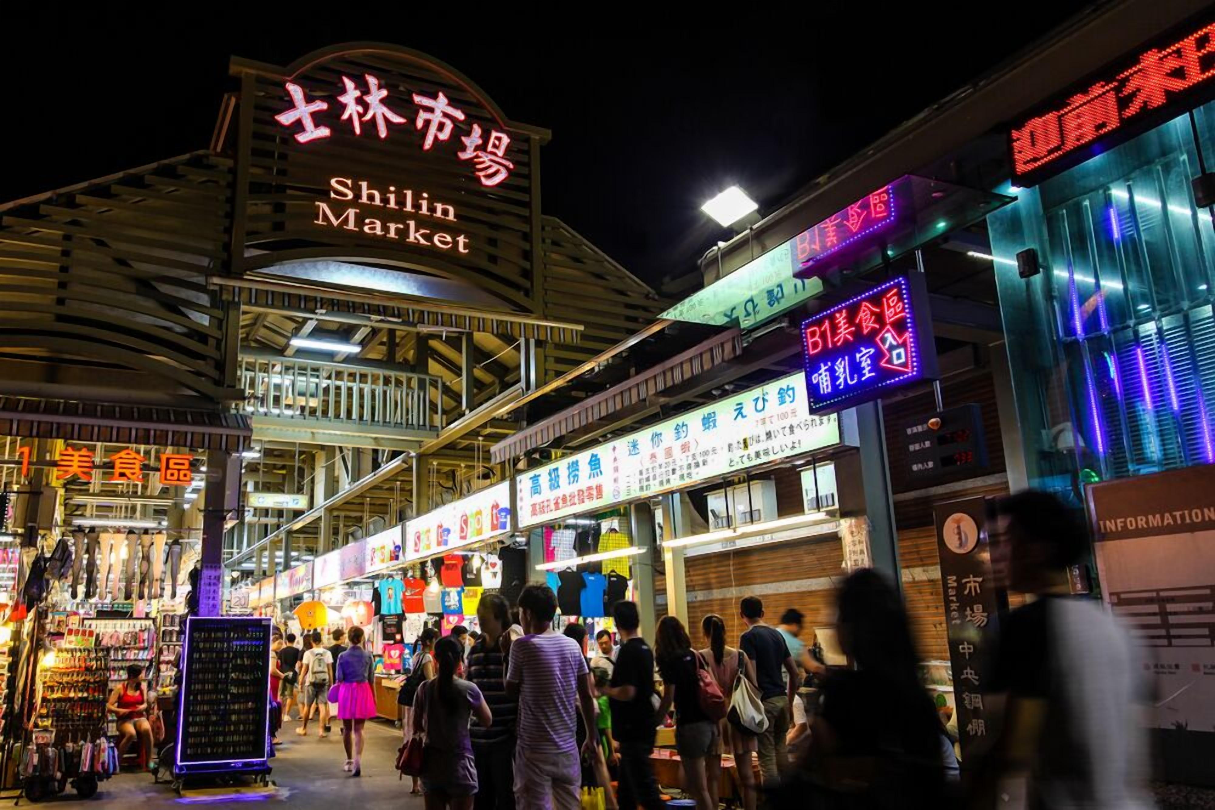 A bustling night market with a prominent sign for Shilin Market.