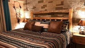 Een knus slaapkamer met een bedovertrek met dessin, een rustiek hoofdbord en een dromenvanger aan de muur.