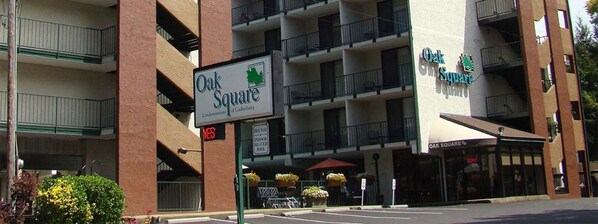 Un edificio de varios pisos con letreros que dicen 'Oak Square' y 'Oak Square Condominium of Gatlinburg'.