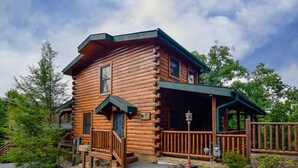 Eine Blockhütte mit Veranda, einer kleinen Treppe und einem Schild, das sie als Herberge kennzeichnet.