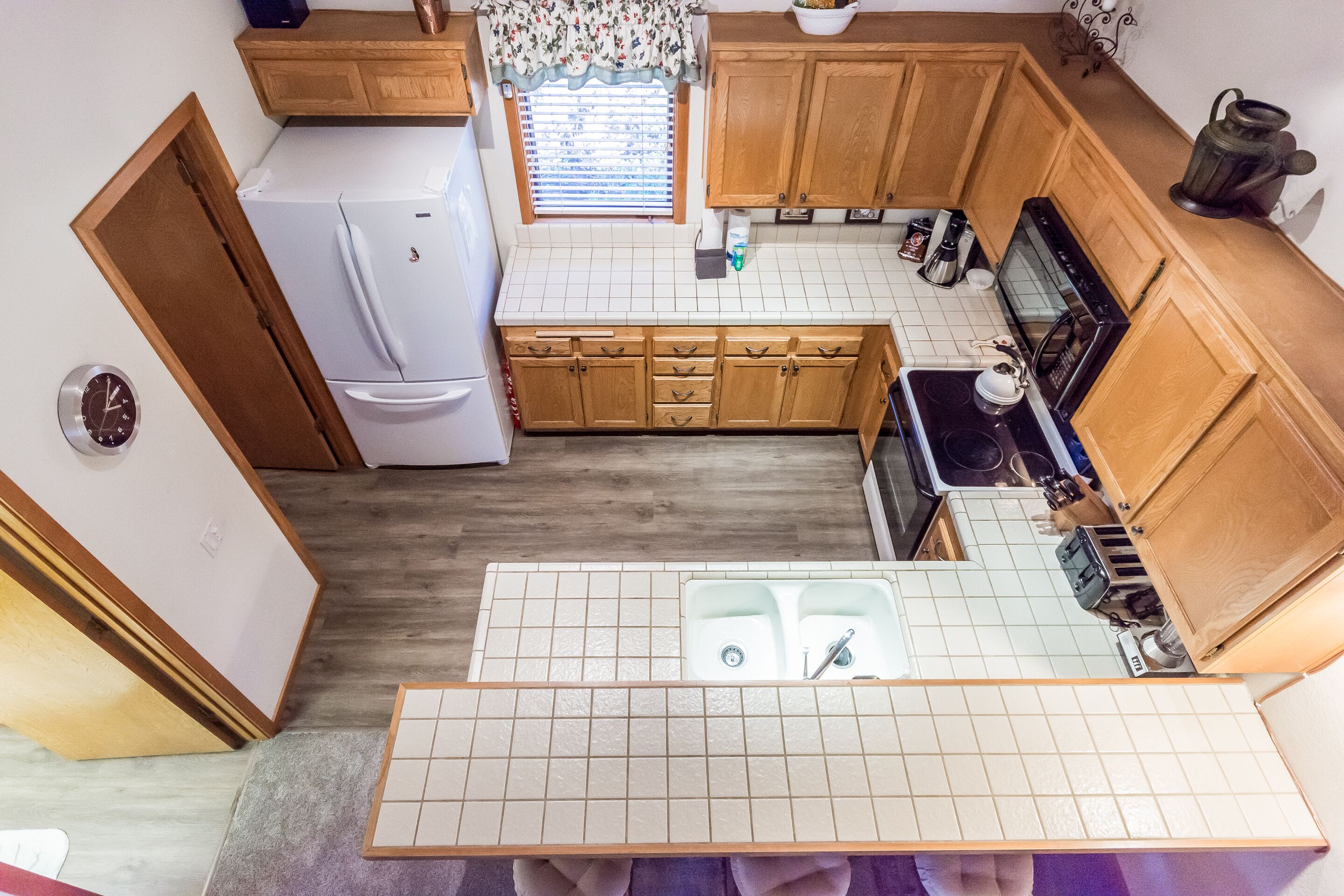 A kitchen with wooden cabinets, a white refrigerator, a stove, and a sink.