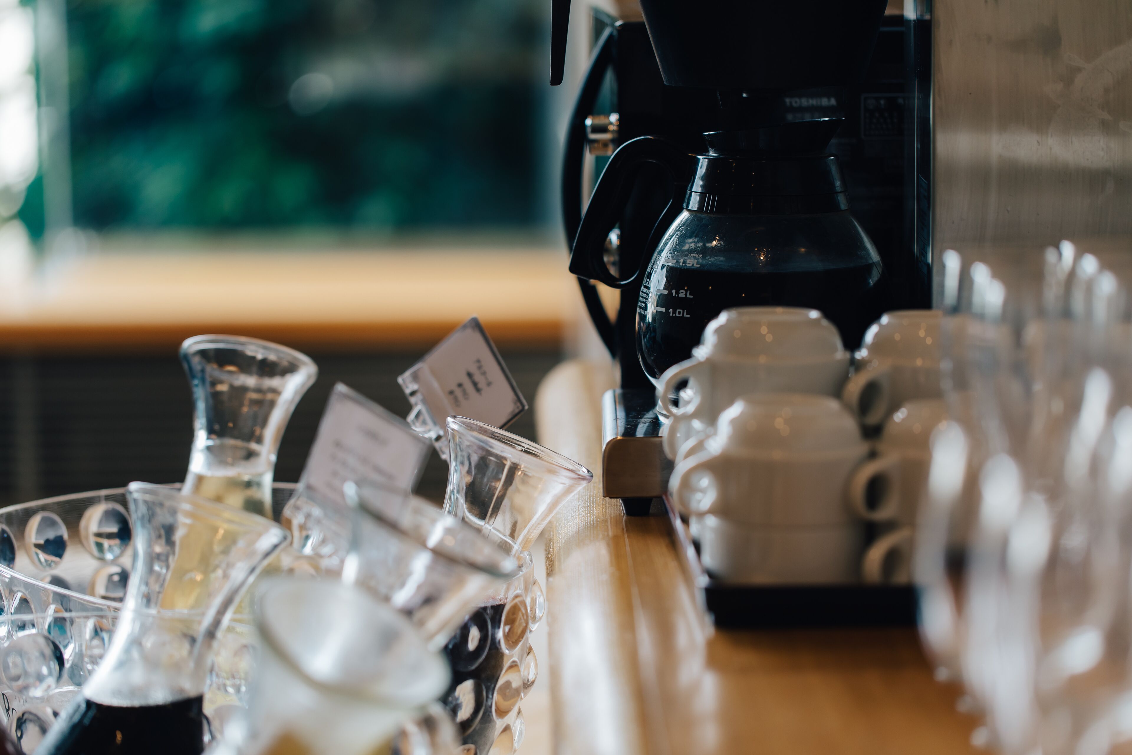 Una cafetera y varias tazas de café sobre una mesa.