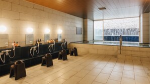 A modern restroom with multiple sinks, benches, and a large window overlooking a waterfall. - Atami Fuga (Atami)