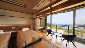 A hotel room with two beds, a balcony with a view of the city, and a small table and chair. - Atami Fuga (Atami)