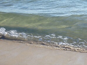Una playa con agua cristalina y olas suaves.