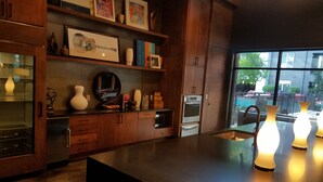 Una cocina moderna con armarios de madera, una isla grande y vistas al exterior a través de un ventanal.
