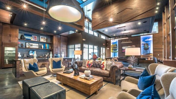 Un vestíbulo amplio con techo alto, muebles modernos y un gran ventanal con vistas a la ciudad.