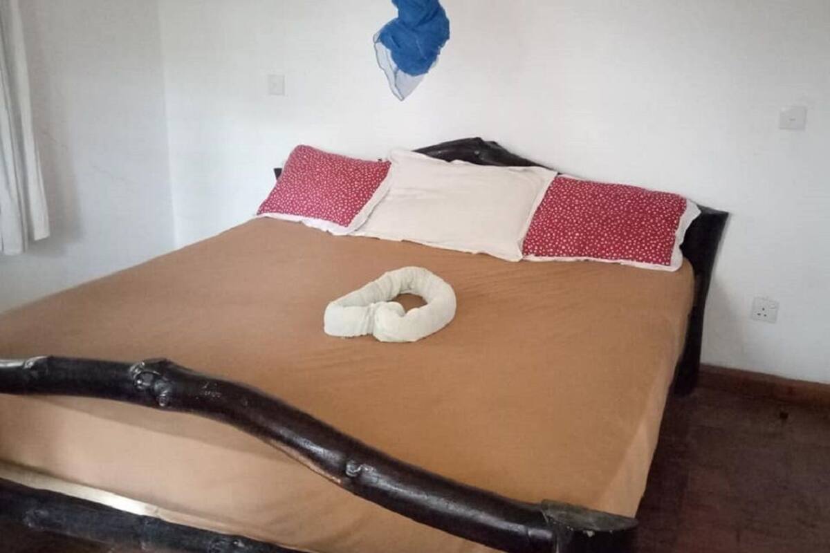 Una cama con dosel, almohadas y cabecero.